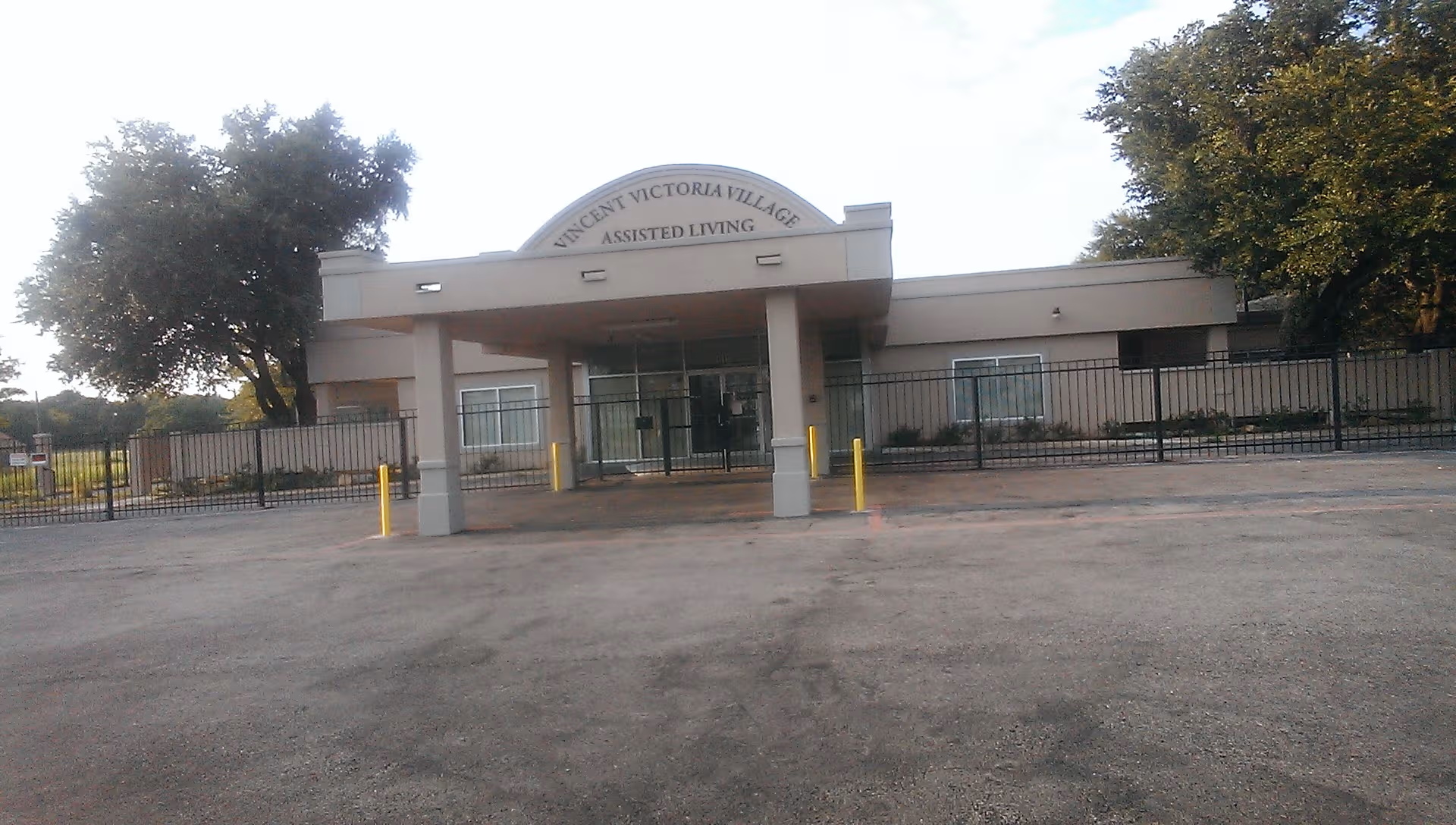 Front view of Vincent Victoria Village Assisted Living building with entrance under curved sign.