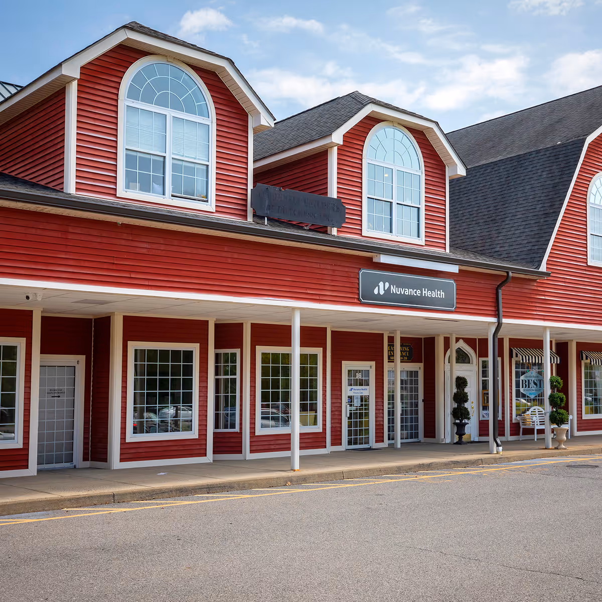 Red storefront building with arched windows and a Nuvance Health Primary Care Hopewell Junction sign.