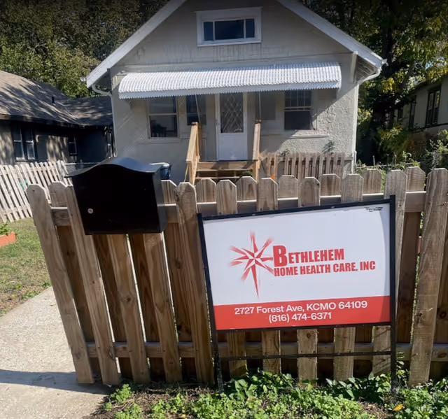 White house with Bethlehem Home Health Care sign behind a wooden picket fence.