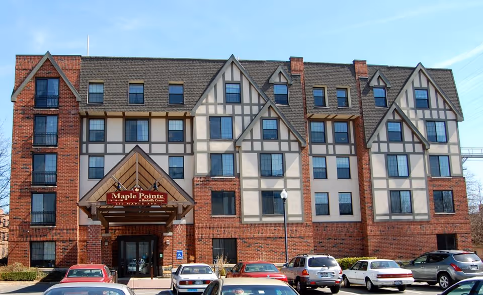 Front exterior of Maple Pointe assisted living building with brick and Tudor-style detailing.