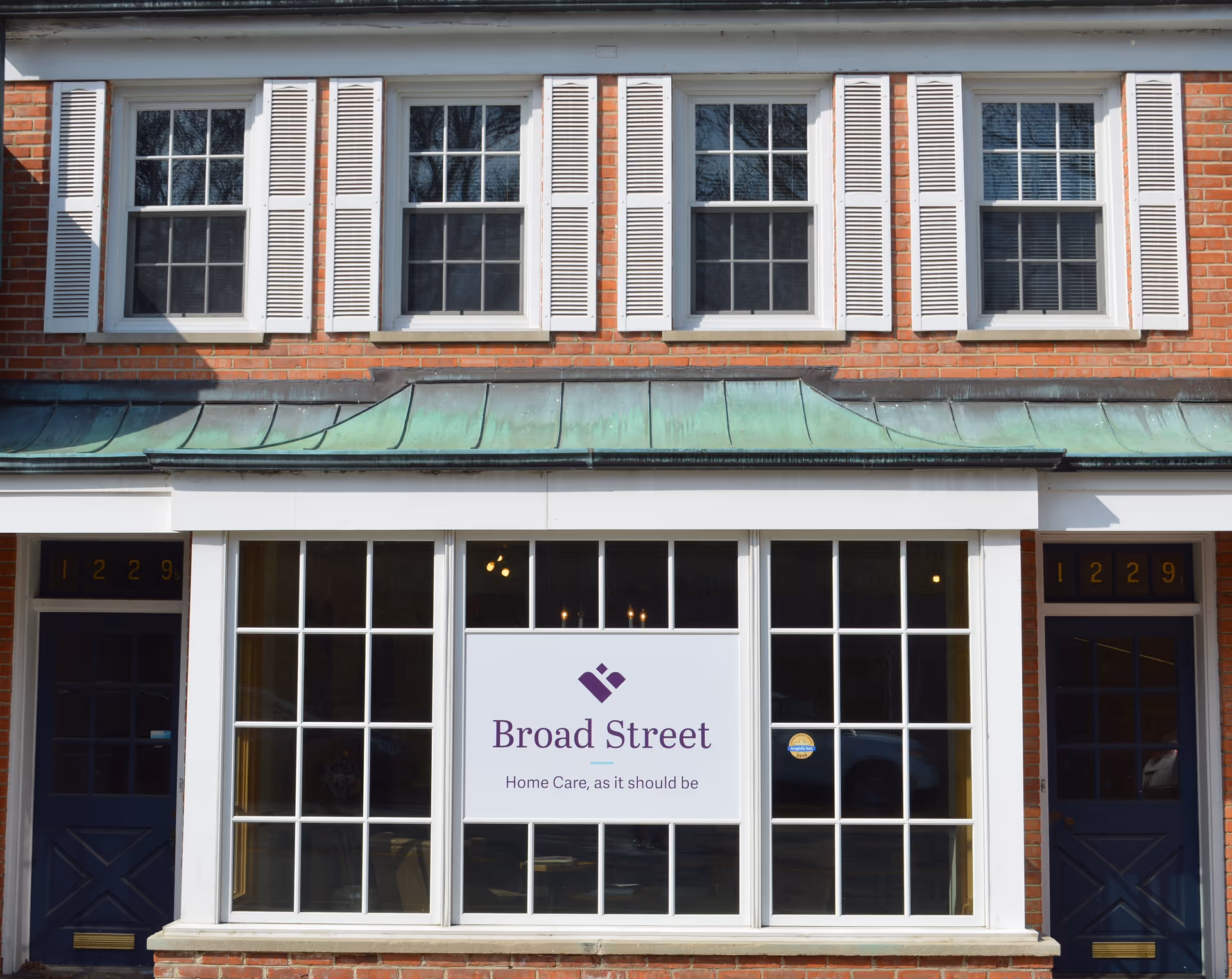Brick building storefront with large windows and a Broad Street Home Care sign.