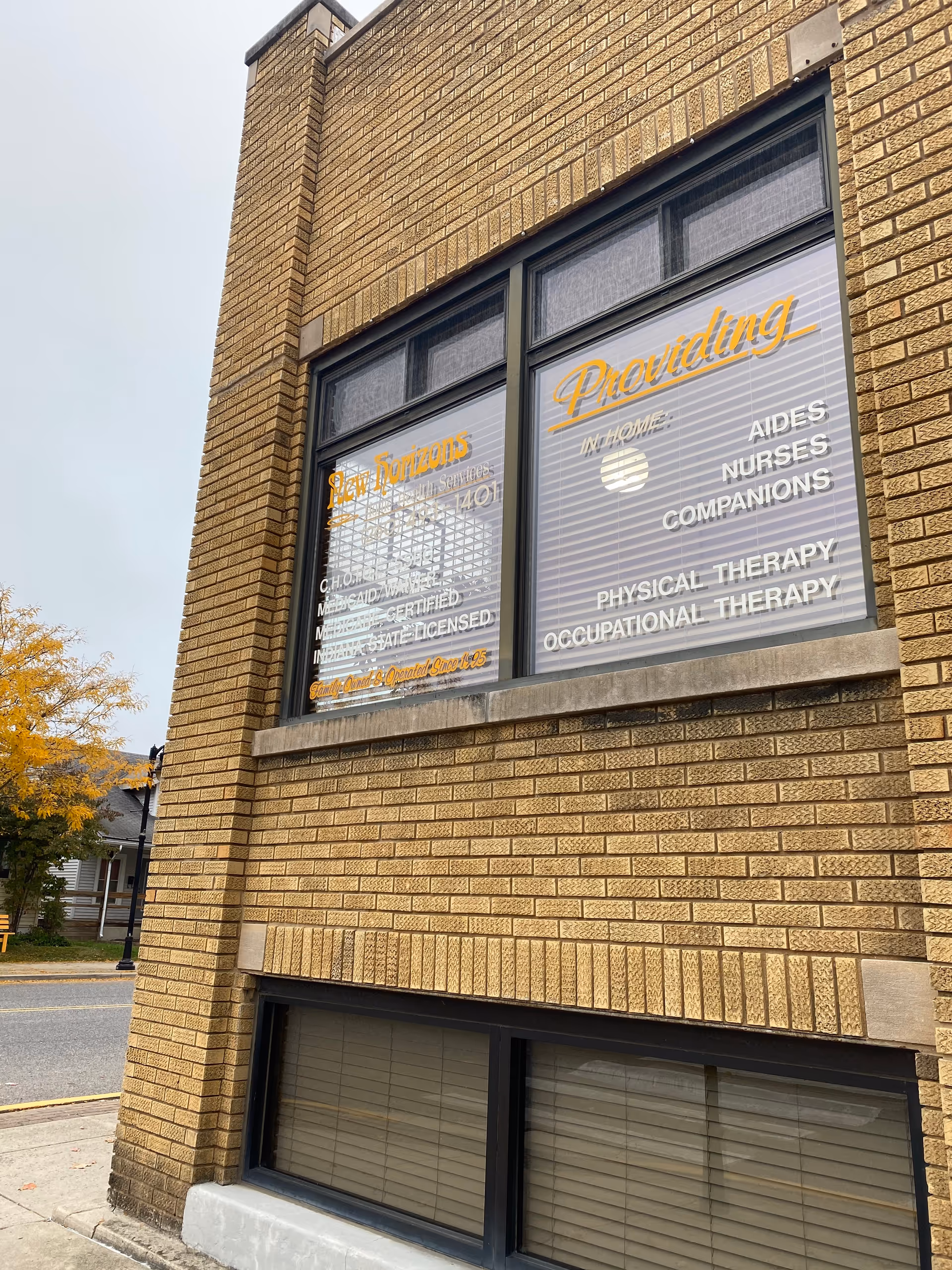 Brick building exterior with large window signs advertising home health services.