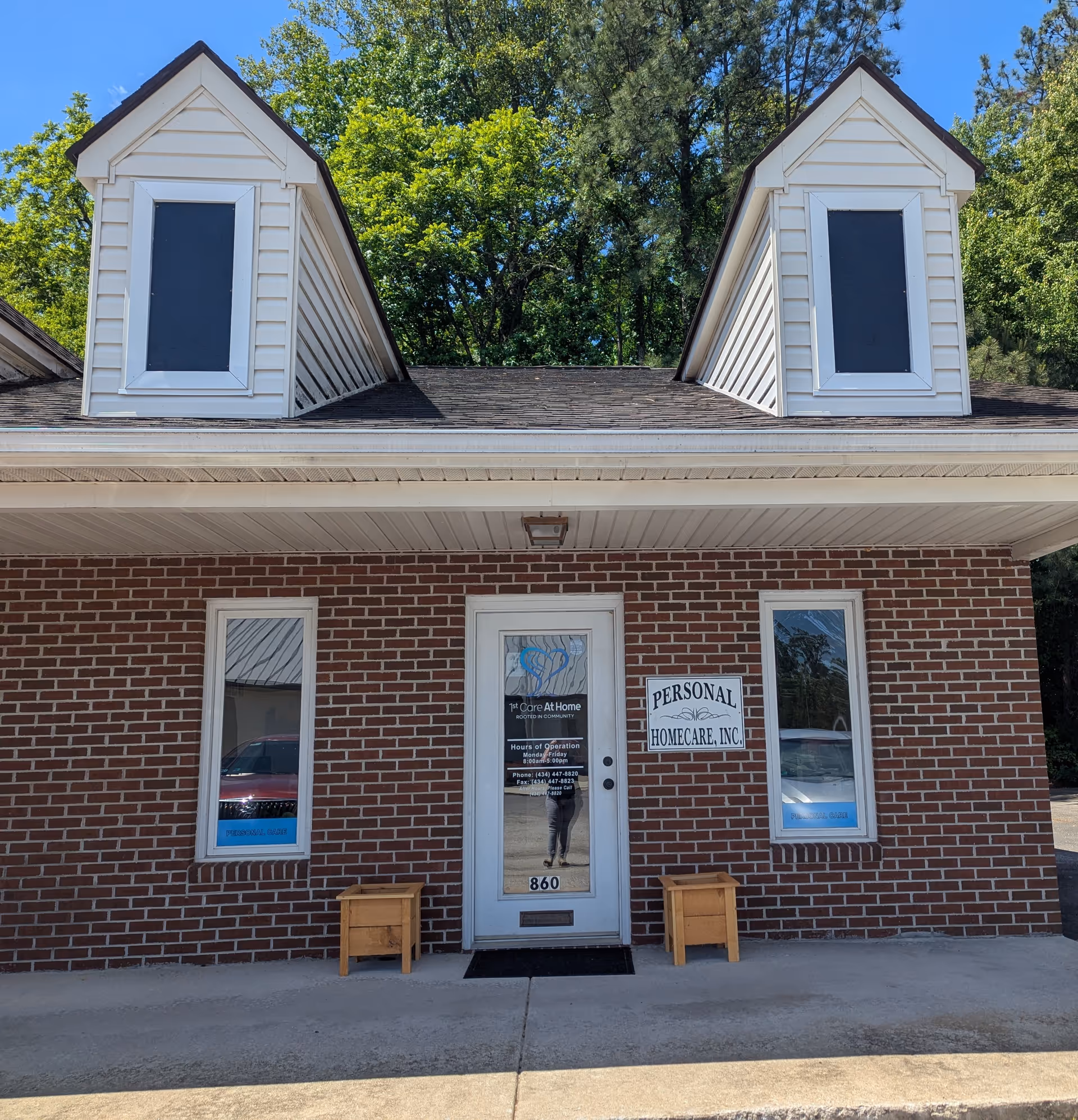 Brick front of a home care facility with a central door and two dormer windows.