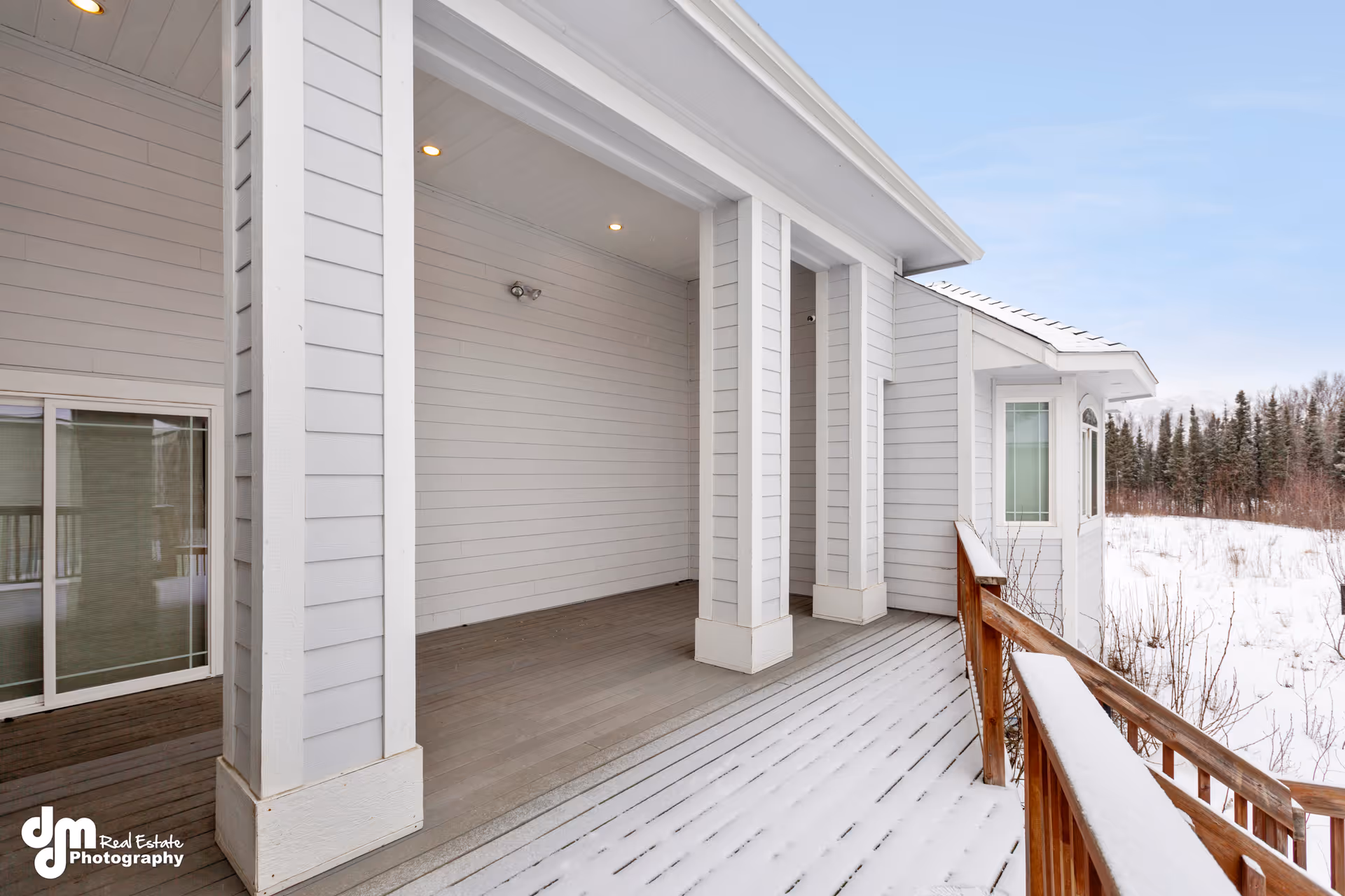 Snowy wooden porch and white siding exterior of Arctic Rose Assisted Living Home.