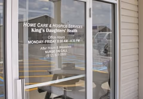 Glass entry door displays Norton King's Daughters' Health Home Care and Hospice office hours.