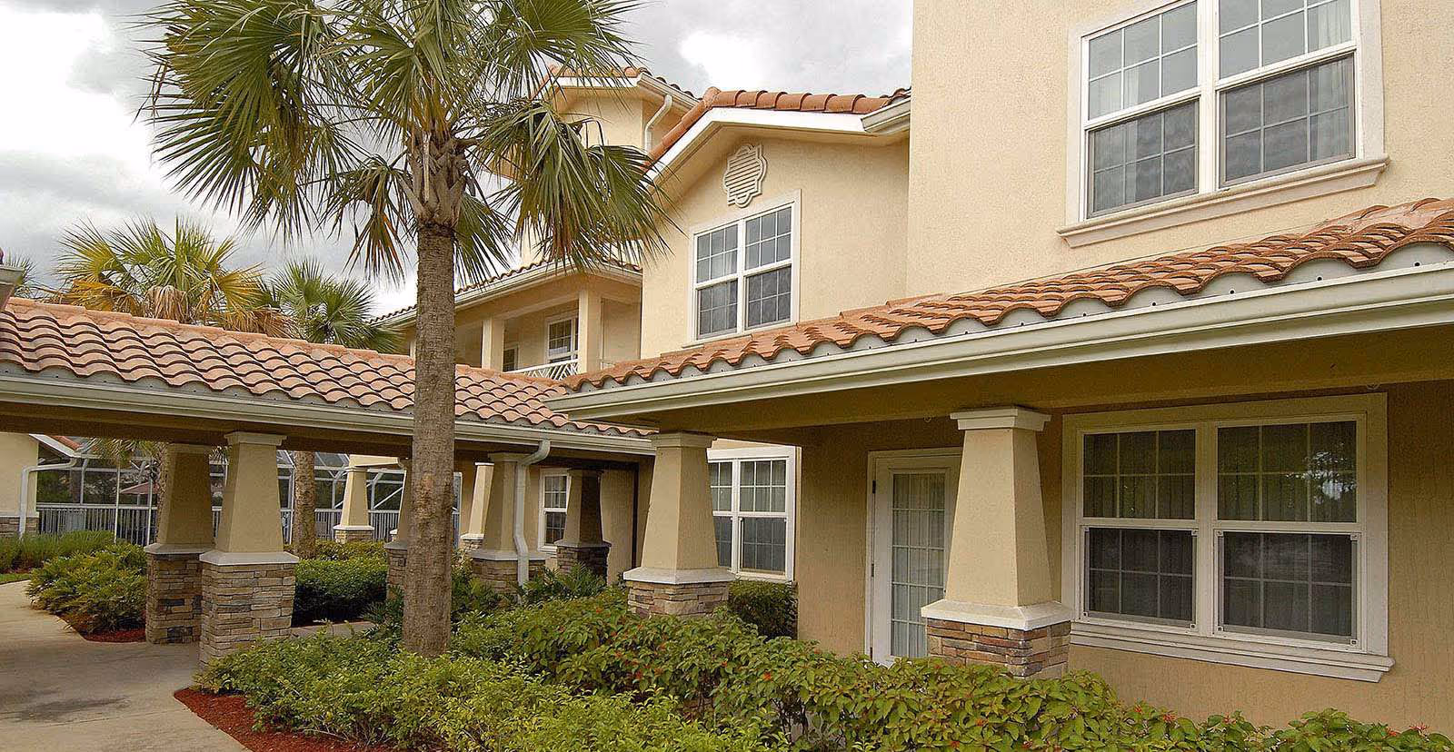 Exterior view of a Windward Palms senior living facility with a covered walkway.