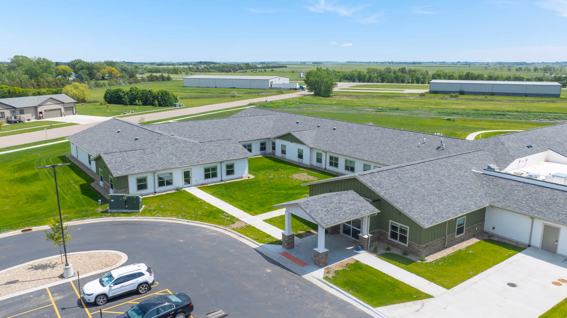 Aerial view of Peaceful Pines Senior Living at Huron, showing low-rise buildings and green lawns.