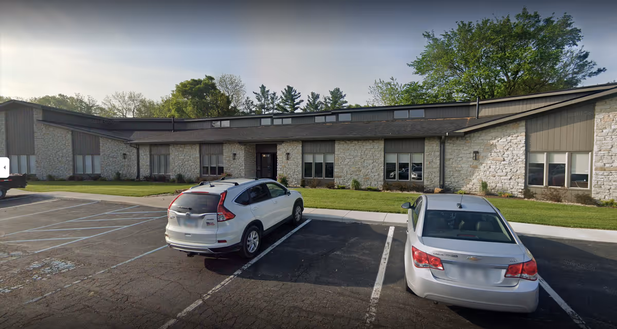 Exterior view of Care United Home Care Agency building with parked cars.