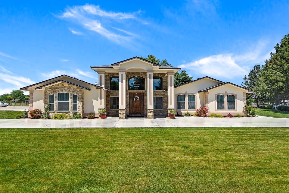 Front view of a single-story senior home with stone accents and a manicured lawn.