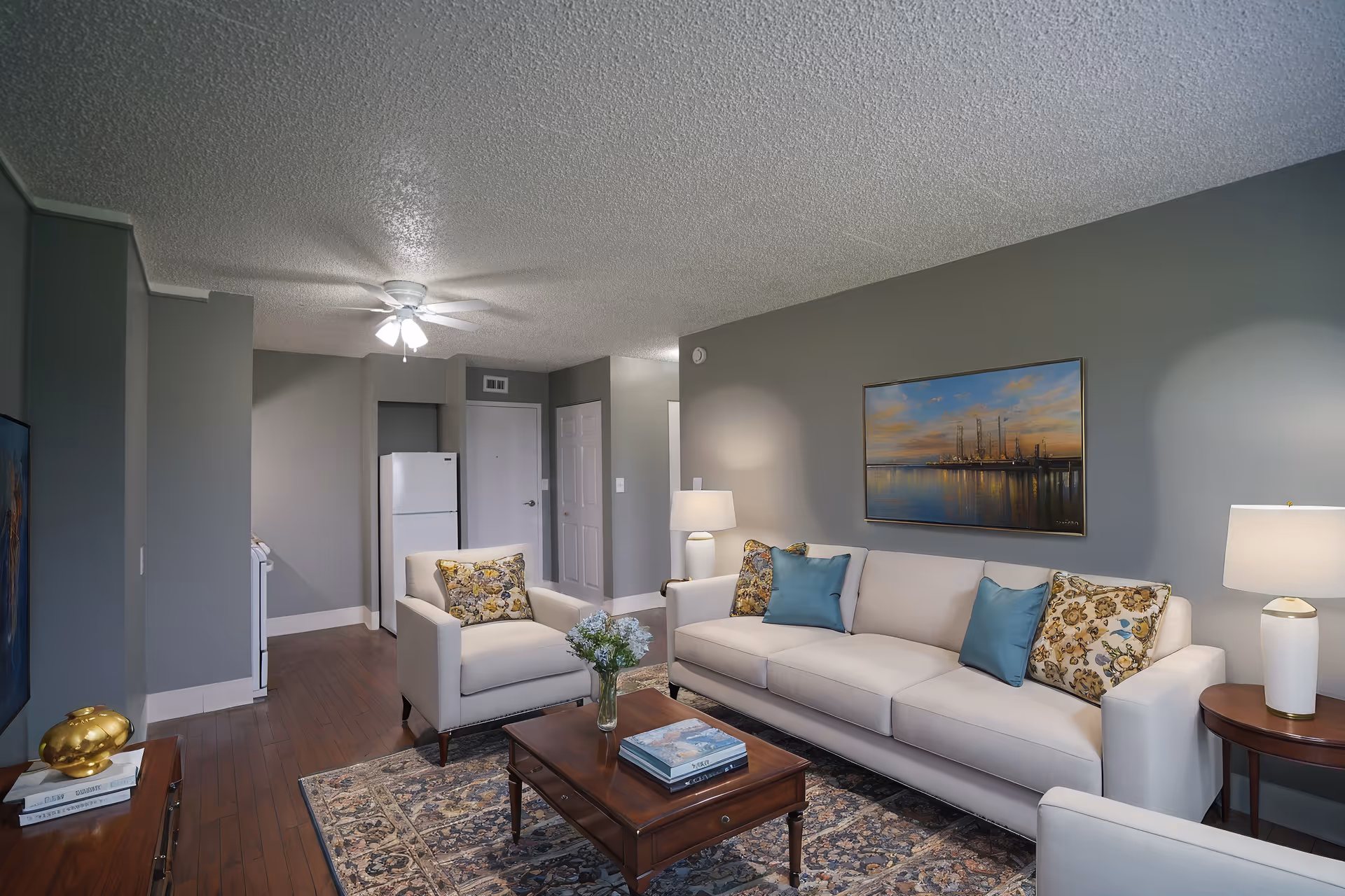 A modern senior living community living room featuring sofa, chairs, coffee table, and artwork.
