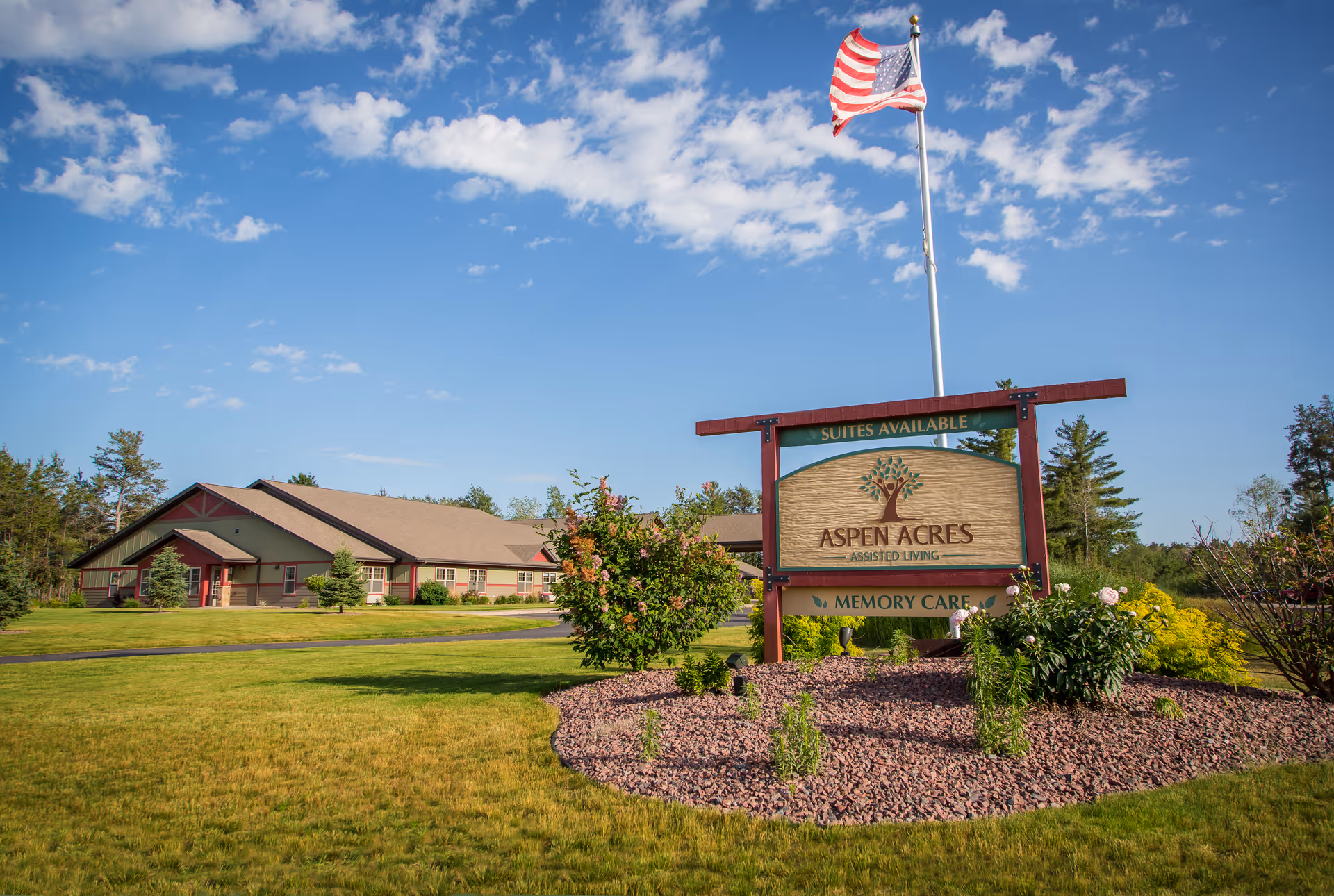 Aspen Acres Assisted Living building with sign and landscaped front yard.