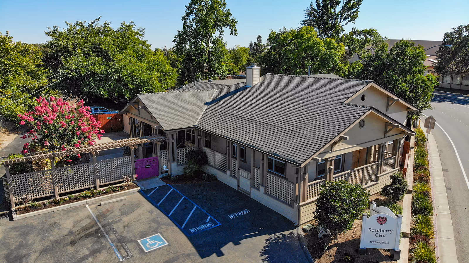 A single-story Roseberry Care building with a parking lot and surrounding trees.