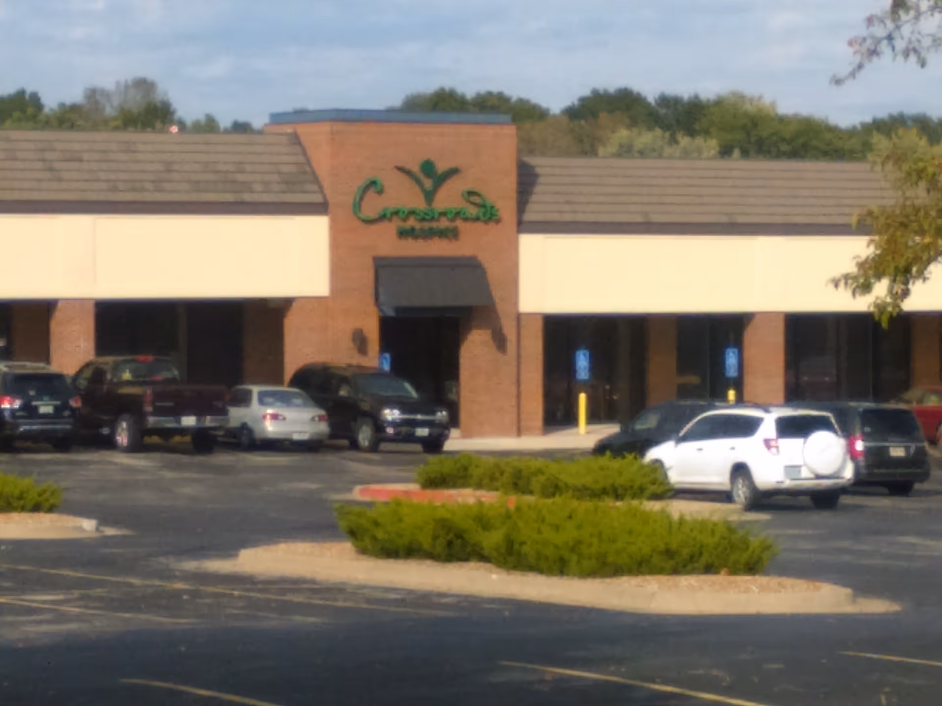 Exterior view of Crossroads Hospice building with parking lot and landscaping.