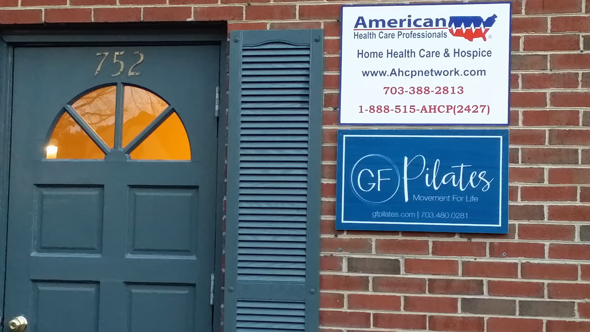 Brick building exterior with a blue door and two signs advertising health services.