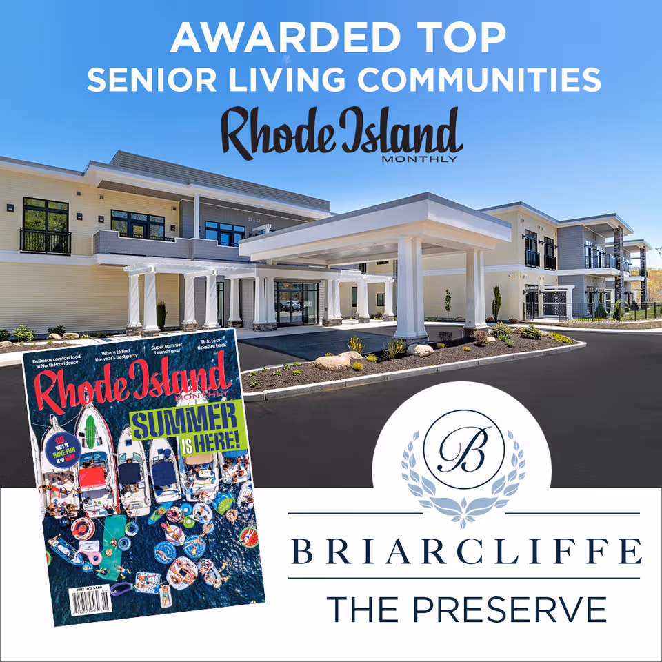 Modern senior living facility exterior with a white portico and landscaped entrance.