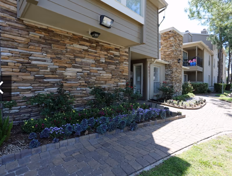 Exterior view of Golden Step Home Health-Care building with stone facade, walkway, and landscaped garden.