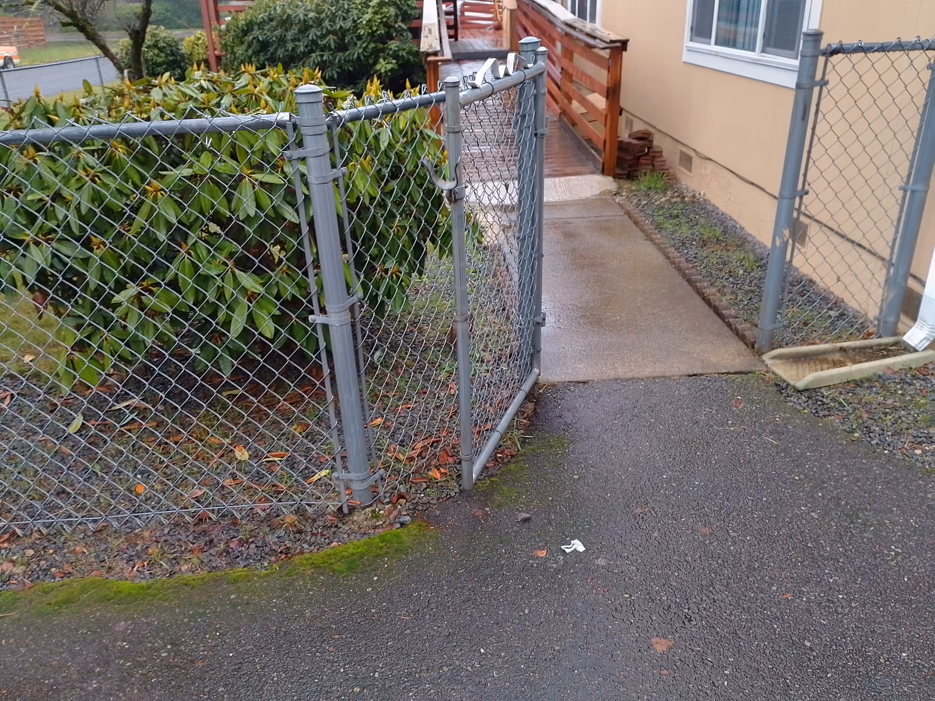 Chain-link fence along a walkway beside a beige building exterior.