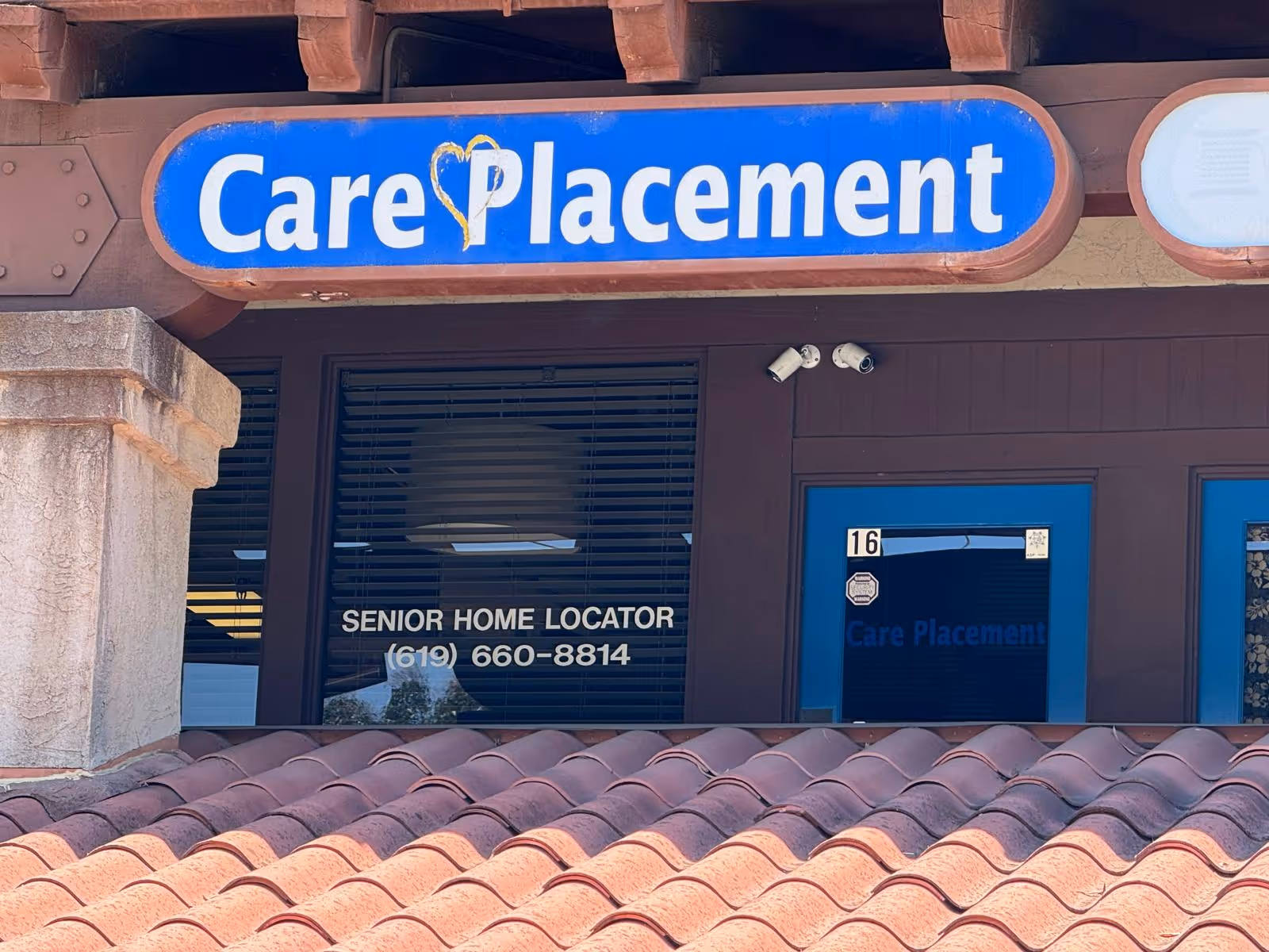 Front exterior of a Care Placement facility with blue sign and door.