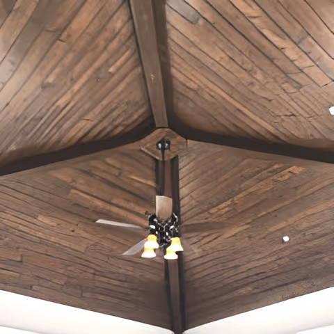 Ceiling view featuring a wooden vaulted ceiling with exposed beams and a ceiling fan with four lights hanging from the center.