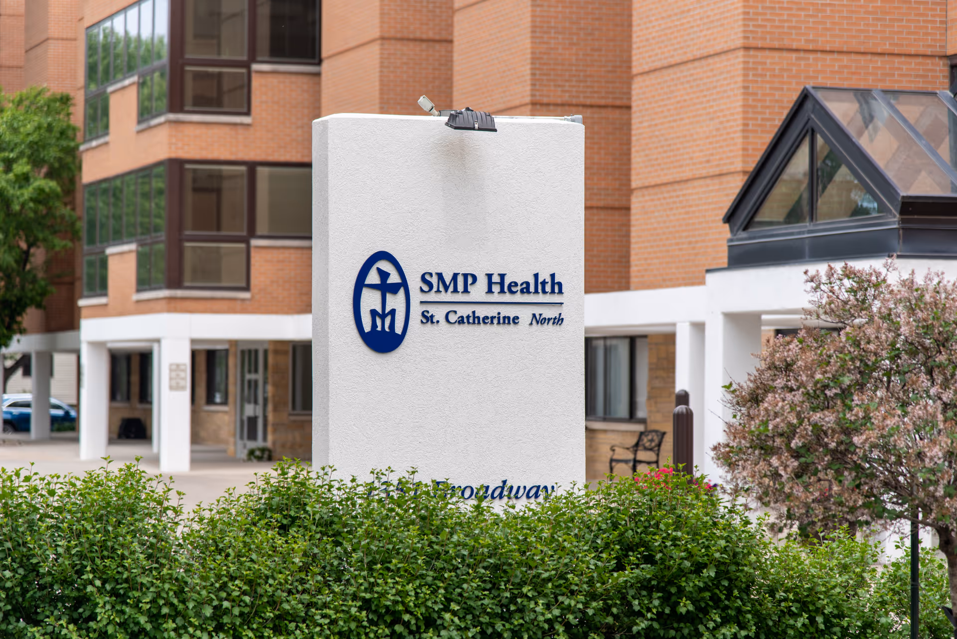 Exterior view of a facility entrance with a white sign reading SMP Health St. Catherine North.