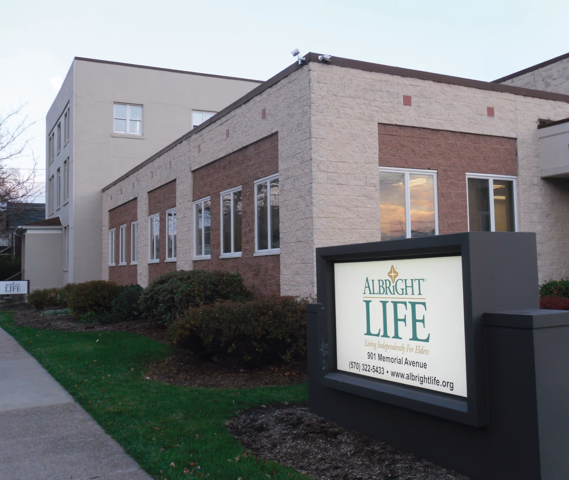 Exterior view of Albright LIFE Lycoming senior living facility with a sign in front.
