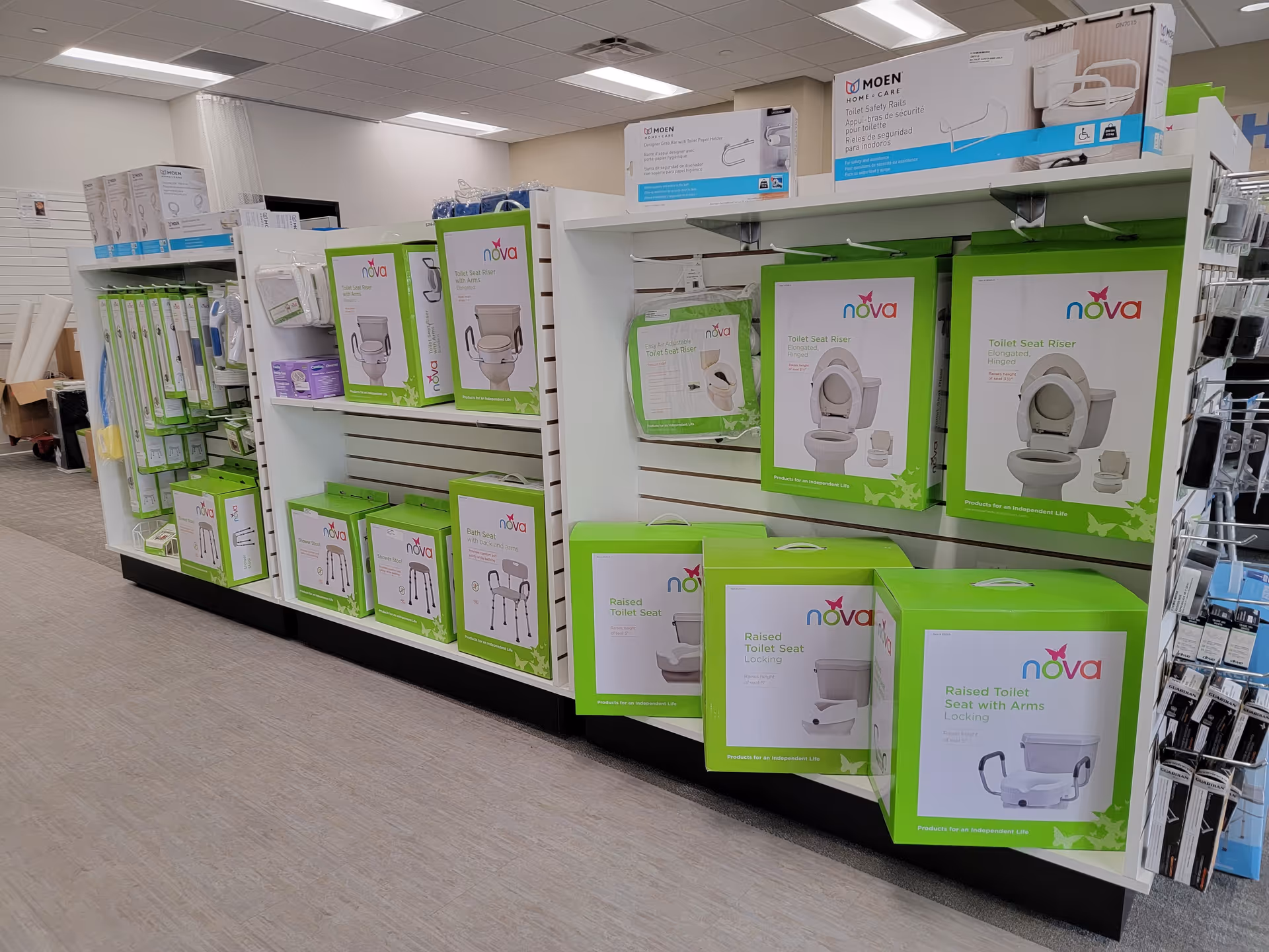 A retail display of Nova brand toilet seats and bathroom aids on shelves.
