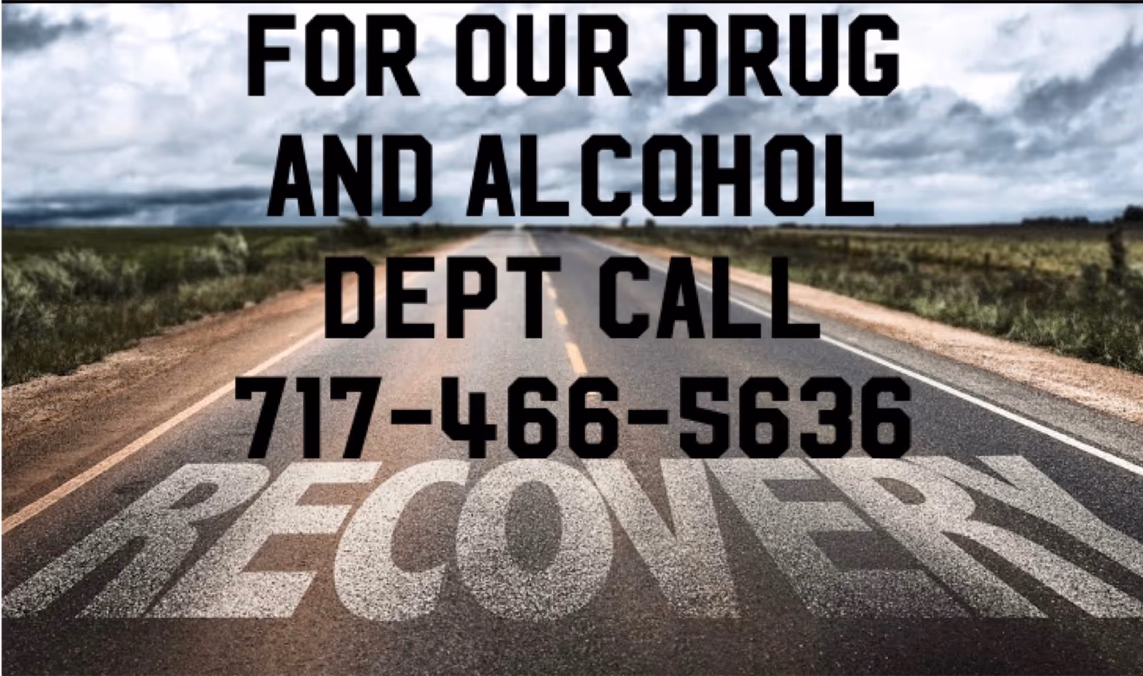 Rural road with large pavement text promoting a drug and alcohol department call and number