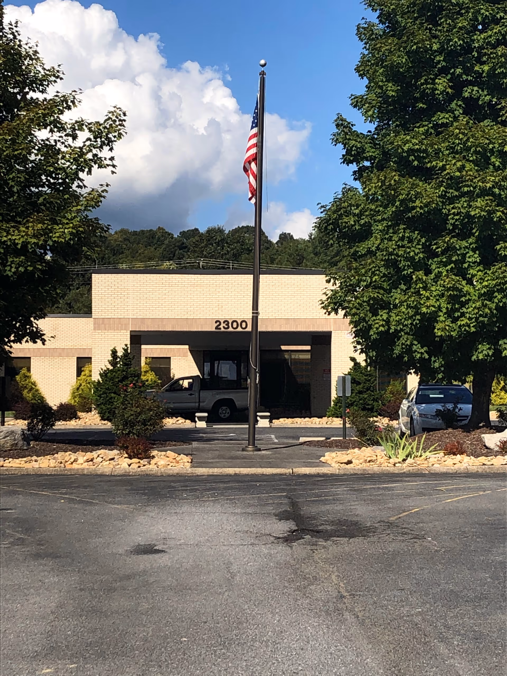 Front exterior of NHC Healthcare - Kingsport with flagpole and entrance.