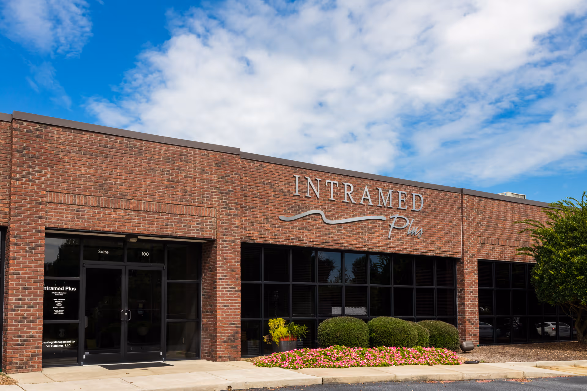 Brick building with Intramed Plus sign and well-kept front landscaping