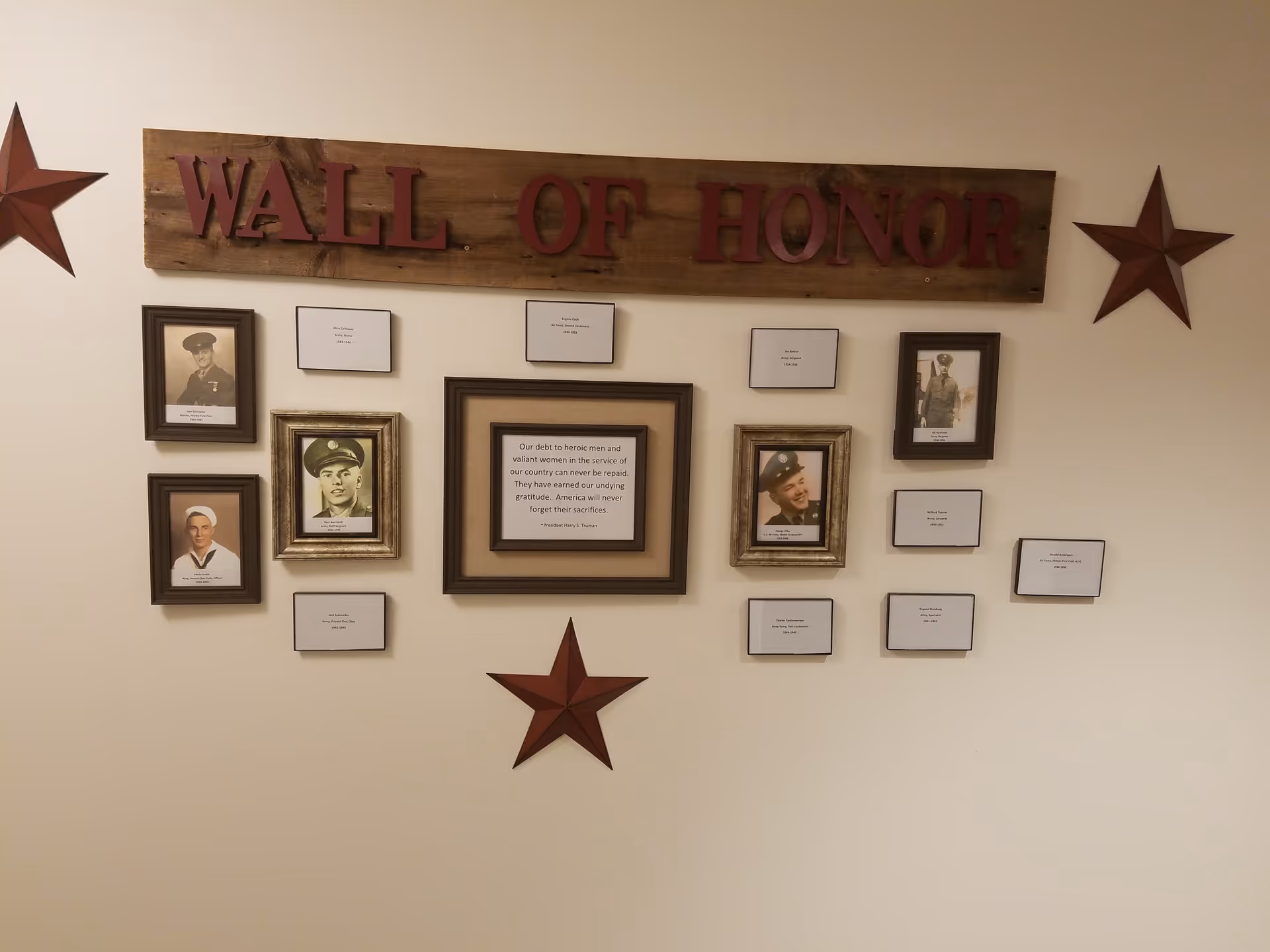 Interior wall display labeled Wall of Honor with framed portraits and small plaques.