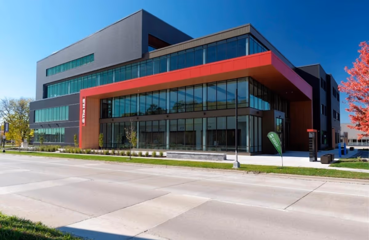 Modern, multi-story building with large glass windows and a red-accent entrance.
