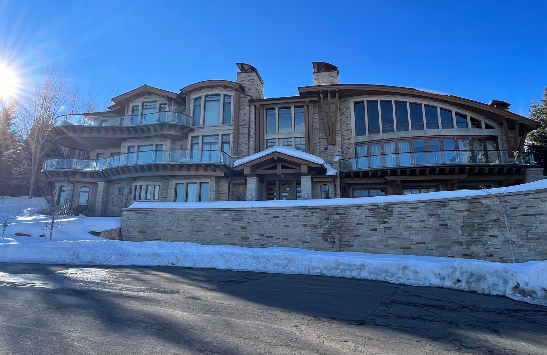 Stone-faced senior living facility front with balconies and snow.