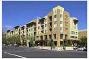 Large multi story senior living building with artists colony design along a street.