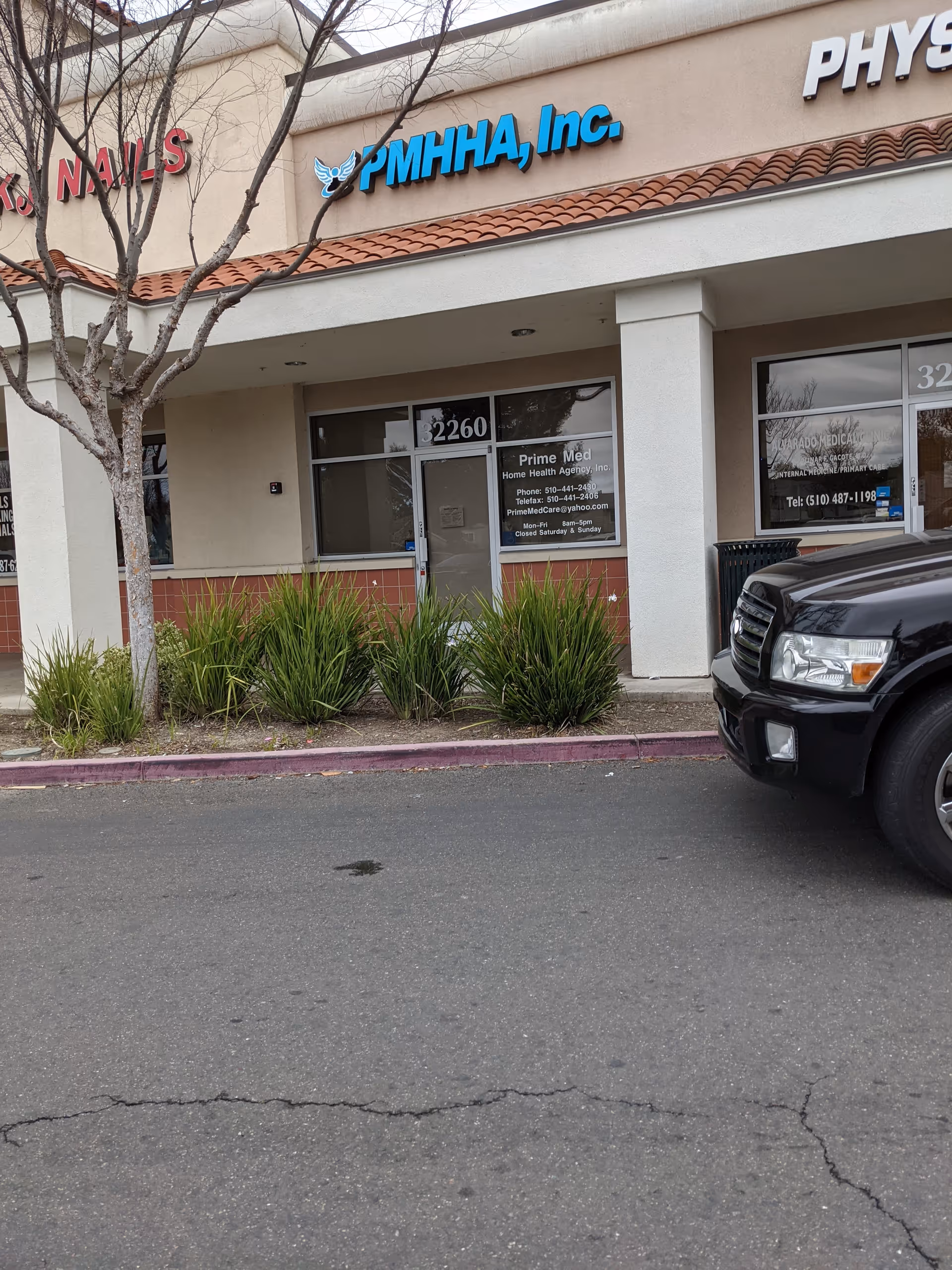 Storefront of Prime Med Home Health Agency with glass doors, windows, and plants outside.