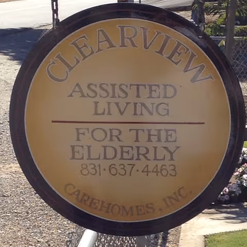 Round outdoor sign for Clearview Assisted Living that reads 'For the Elderly' and shows a phone number.