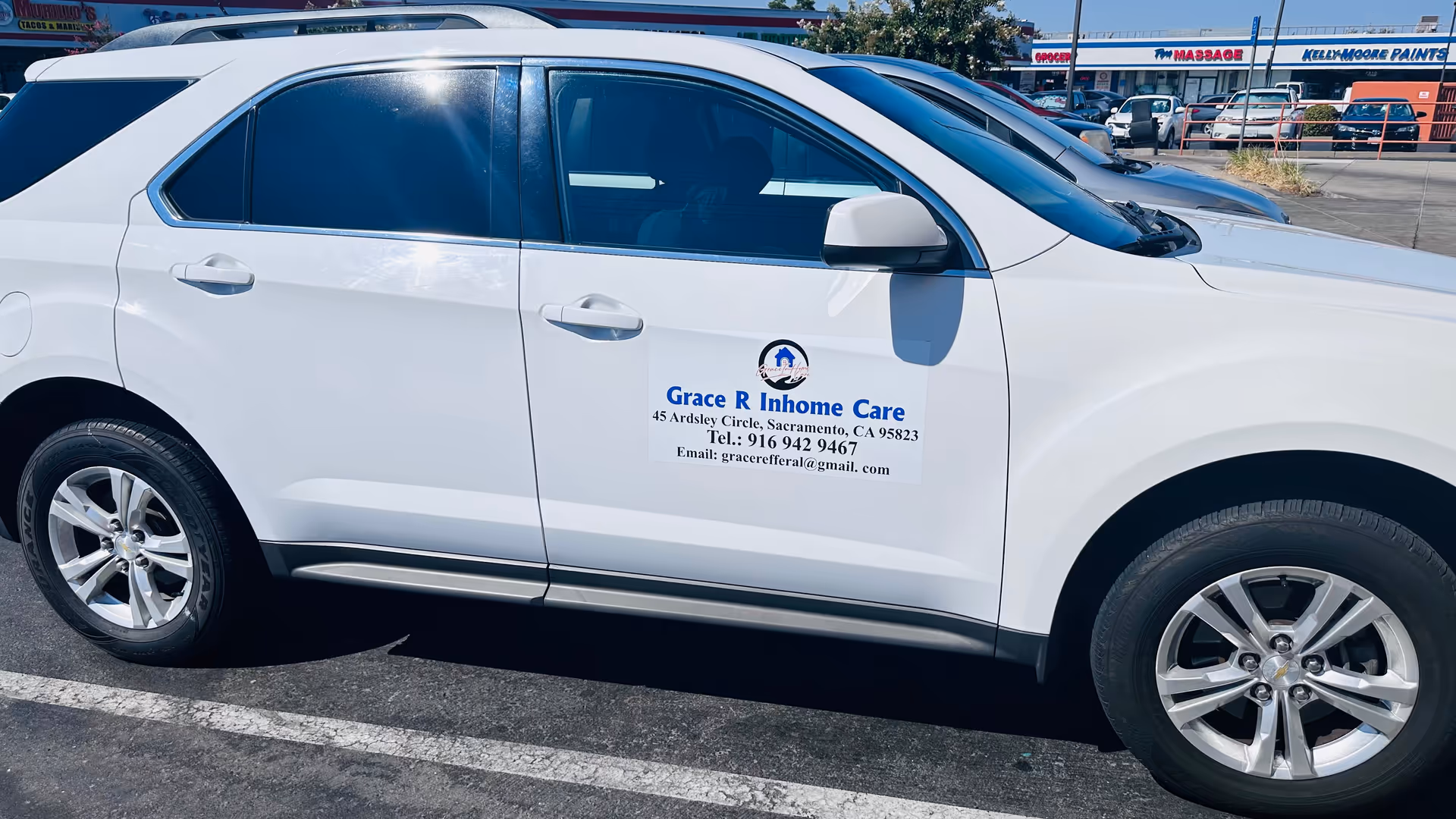 White Grace Inhome Care vehicle parked in a lot with storefronts in the background.