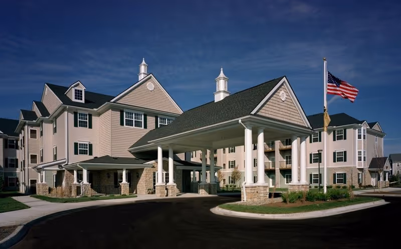 Rose Terrace Cottages exterior featuring a covered entrance with columns and an American flag.
