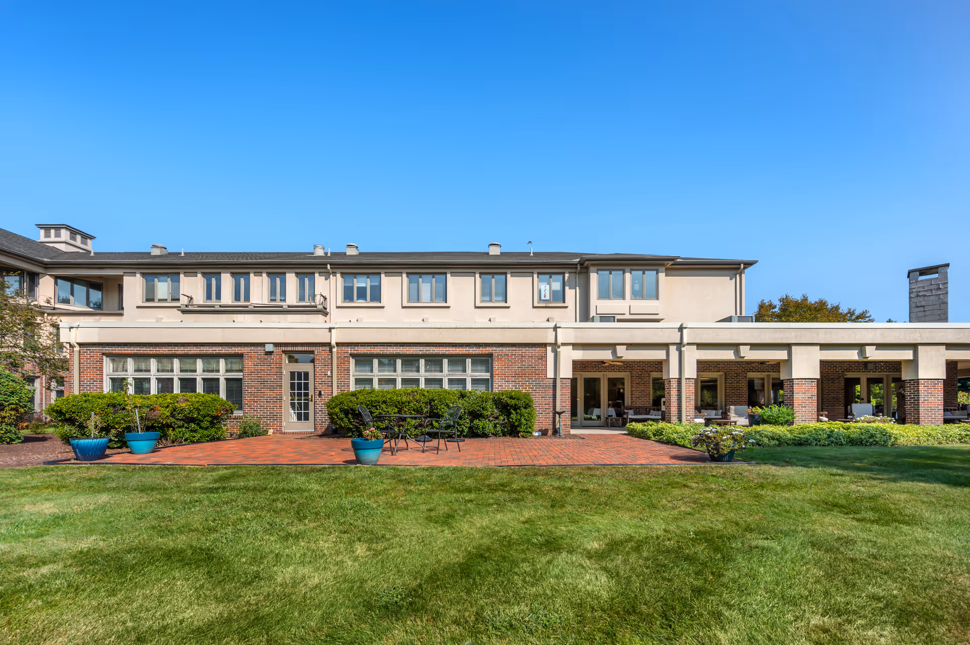 Front exterior of Brookdale Chatfield with brick facade, lawn, and patio seating.