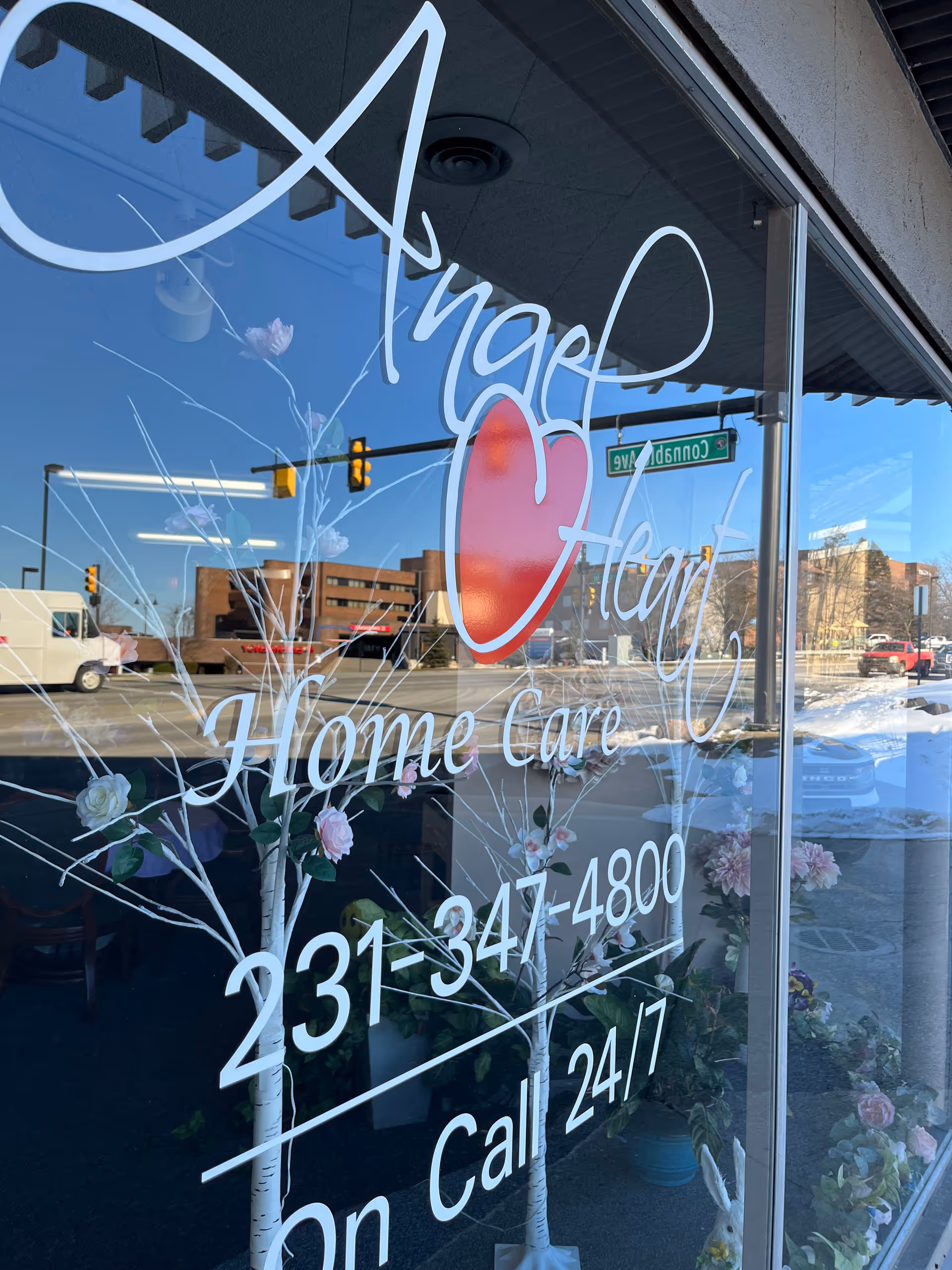 Storefront window displays Angel Heart Home Care logo and contact information.