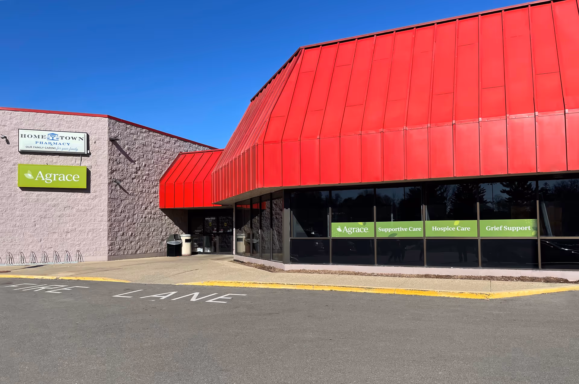 Exterior view of a building with red awnings, Agrace signage, and glass storefront.