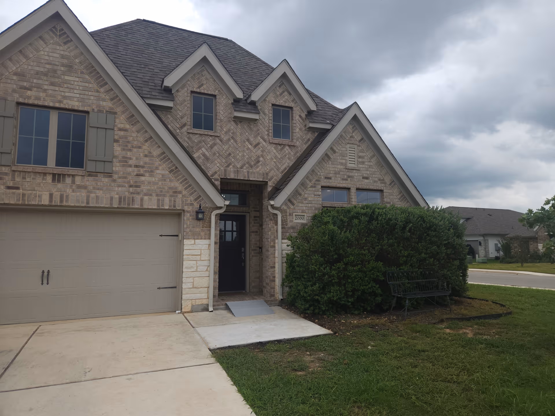 Front view of a brick, townhouse-style senior home with a two-car garage and entry.