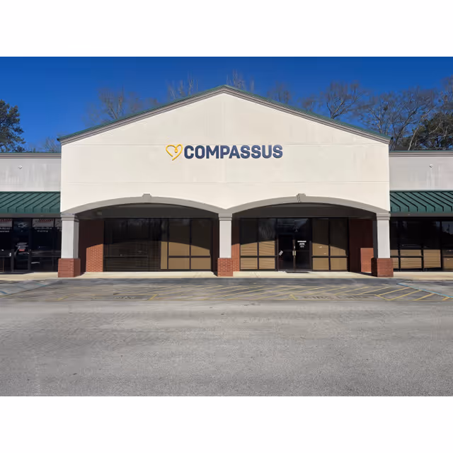 Front view of a Compassus building exterior with arched entrances and brick columns.