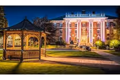 Nighttime exterior view of Washington Odd Fellows Home, a lit, grand building with a gazebo.