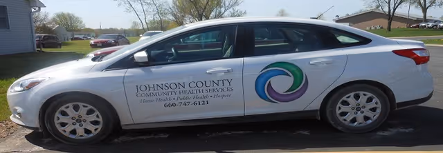 White sedan with Johnson County Community Health Services branding parked outdoors