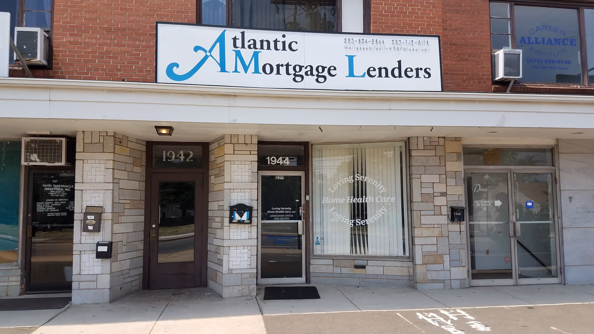 Brick storefront with Atlantic Mortgage Lenders sign and window advertising Loving Serenity Home Health Care.