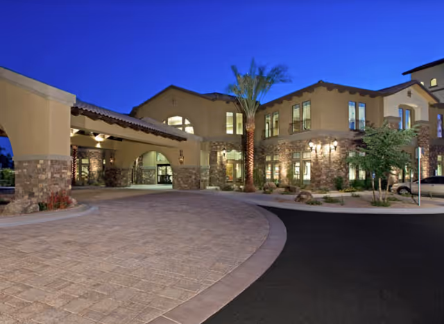 Exterior view of La Siena senior living facility at dusk with a lit entrance.