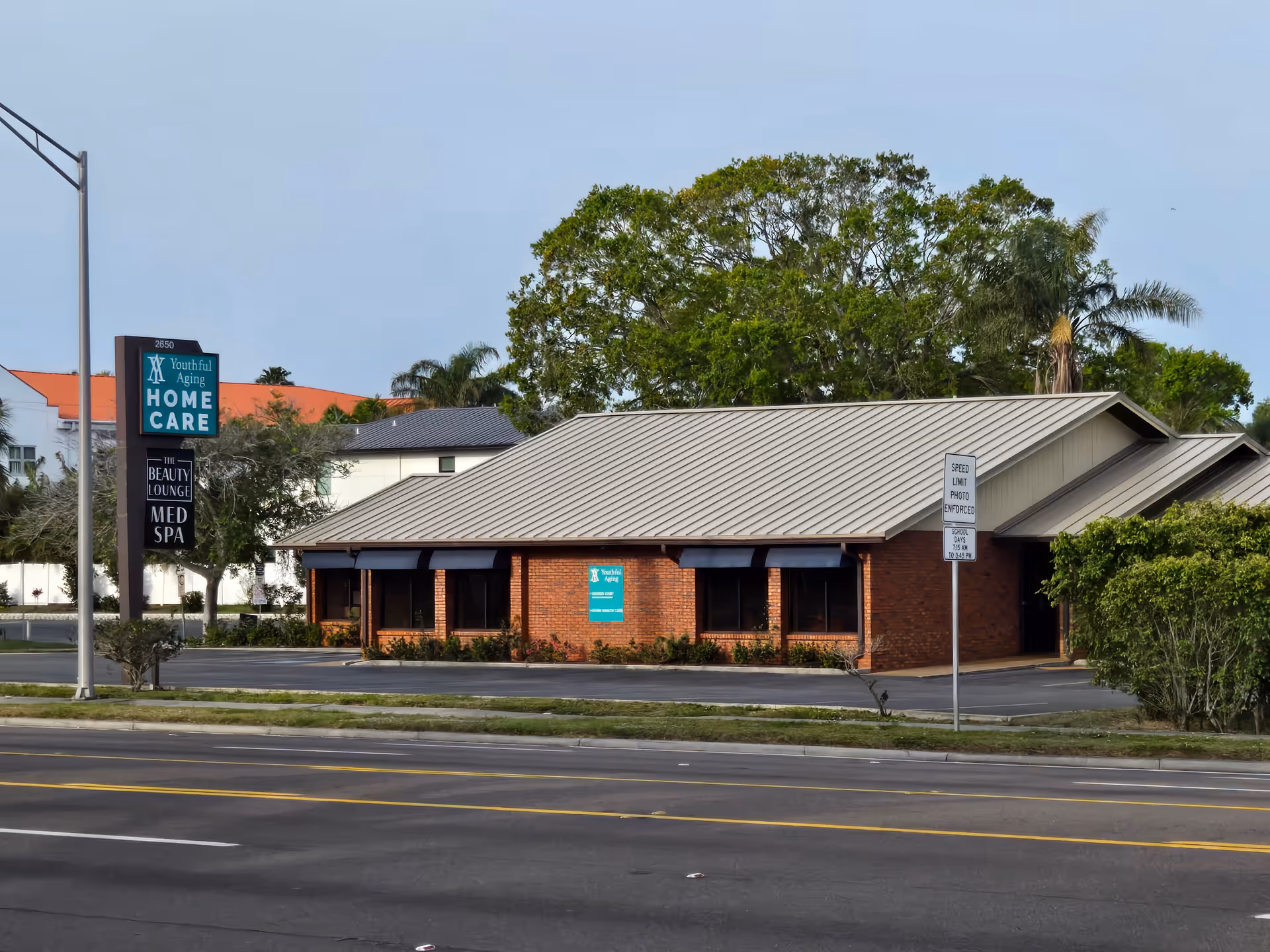 Brick, single-story building with Youthful Aging Home Care sign along a parking lot.