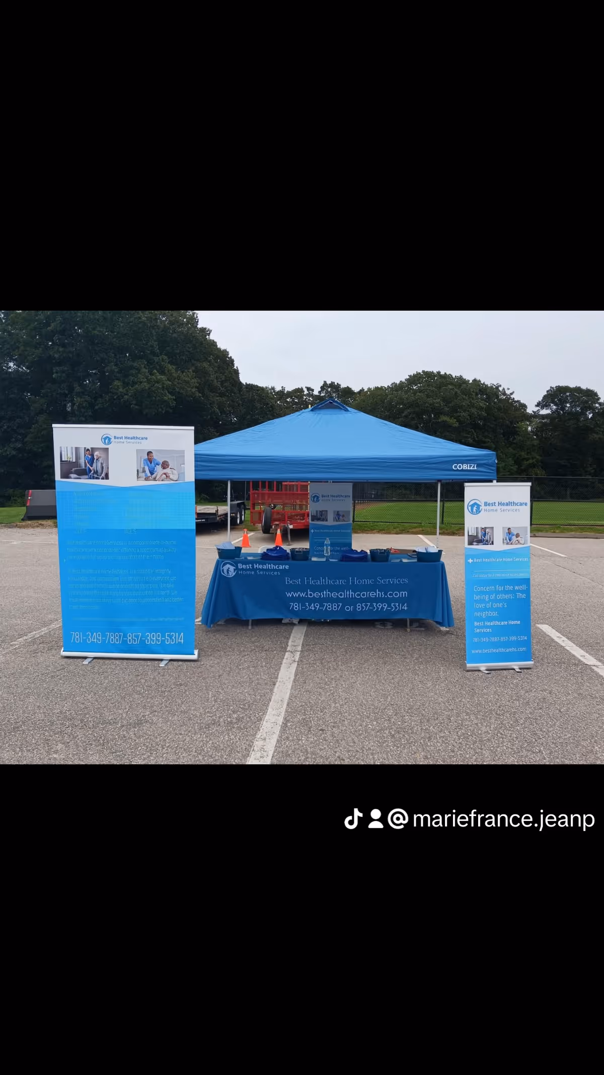 Blue tent booth with banners for Best Healthcare Home Services in a parking lot.