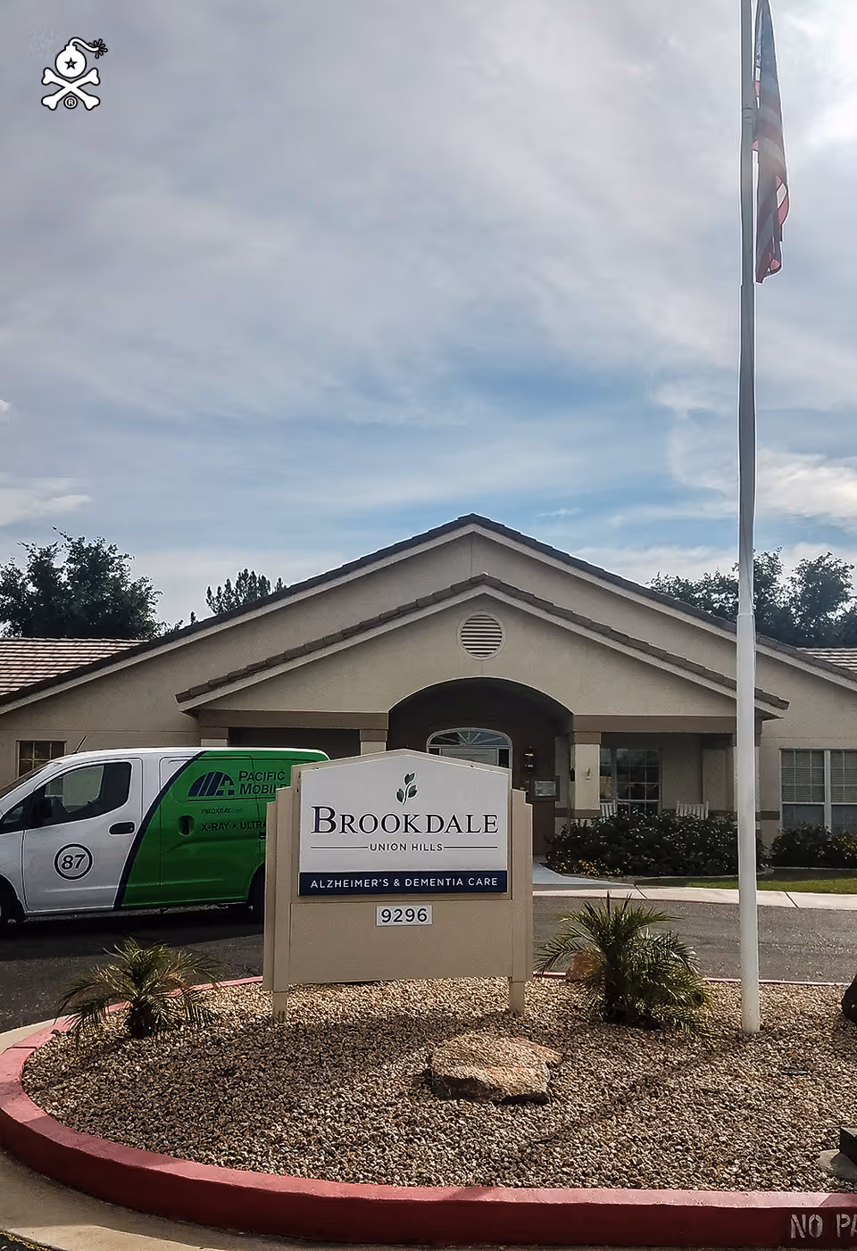 Front view of Brookdale Union Hills senior living facility with entrance sign and van.