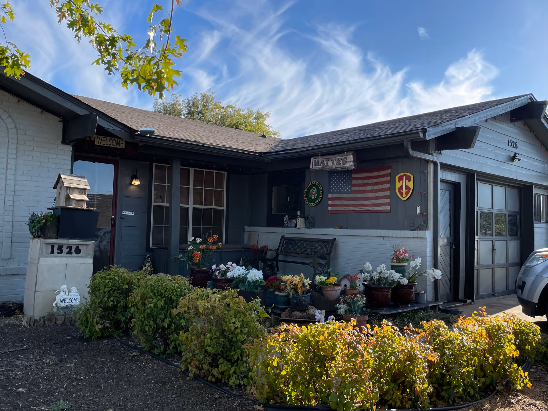 Front exterior of a small facility with a welcoming entrance and potted flowers.